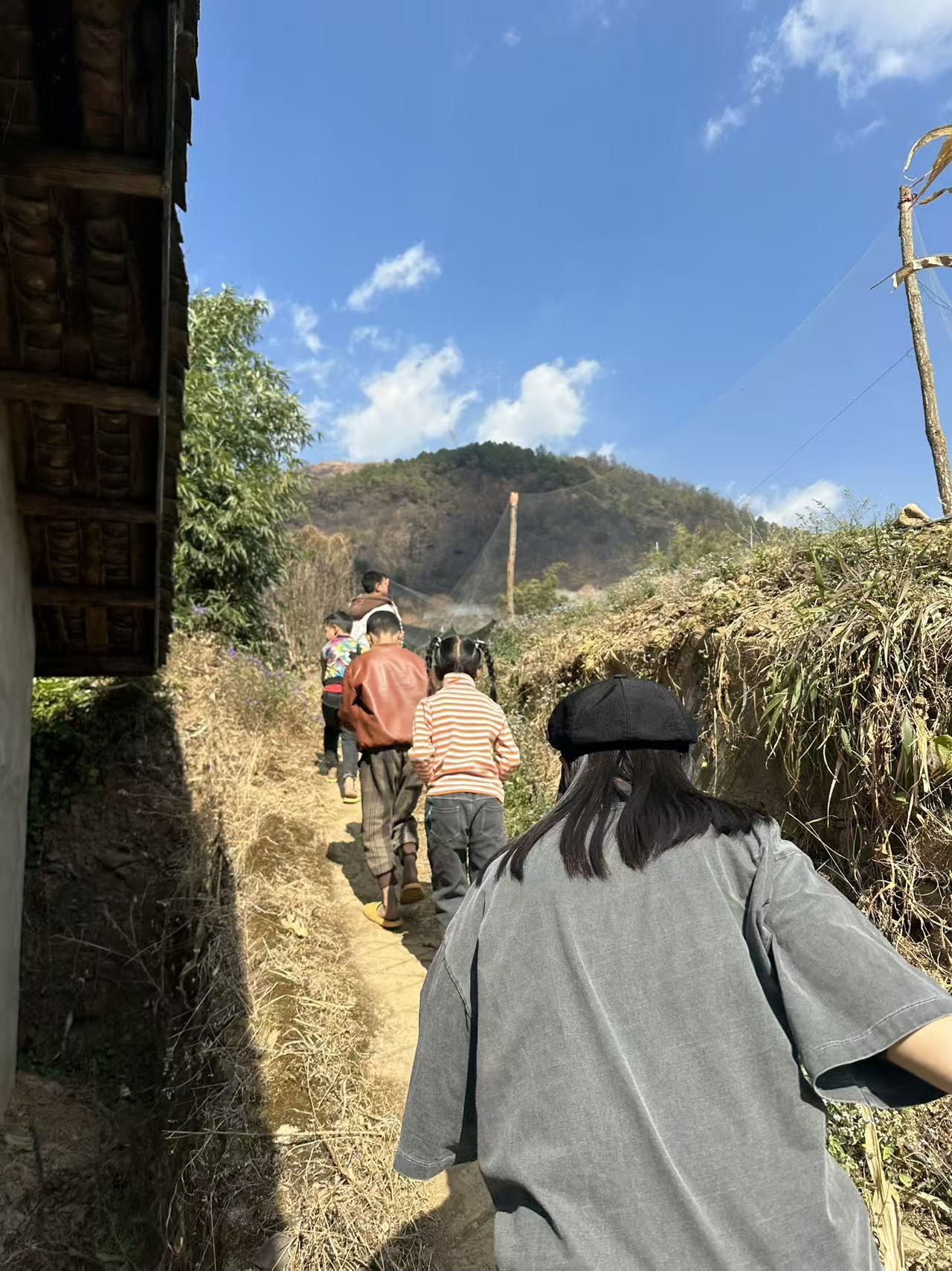 People walking up a narrow hill path