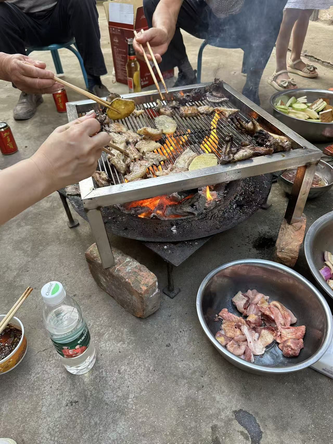 Hands reaching toward a barbecue grill